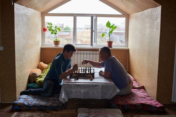 Kasachischer Vater Und Sohn Sitzen Tisch Und Spielen Schach — Stockfoto