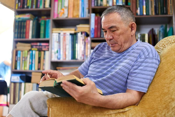 Взрослый Казахский Читать Книгу Сидя Домашней Библиотеке — стоковое фото