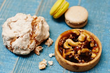 ahşap arka plan, kase ve beze cookie yer renkli macaroons kümesi yakın çekim  