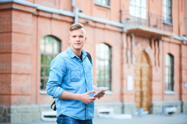 kot gömlek ve tablet pc Üniversitesi önünde duran süre tutan kot yakışıklı öğrenci 