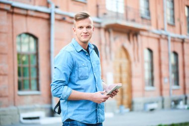 kot gömlek ve tablet pc Üniversitesi önünde duran süre tutan kot yakışıklı öğrenci 