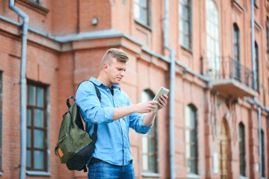 öğrenci tablet pc dururken Üniversitesi güneşli gün kullanarak kot gömlek 
