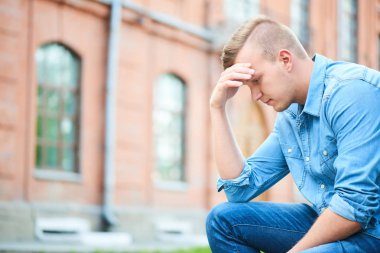 kot gömlek ve turuncu tuğla ev oturan kot dalgın öğrenci 