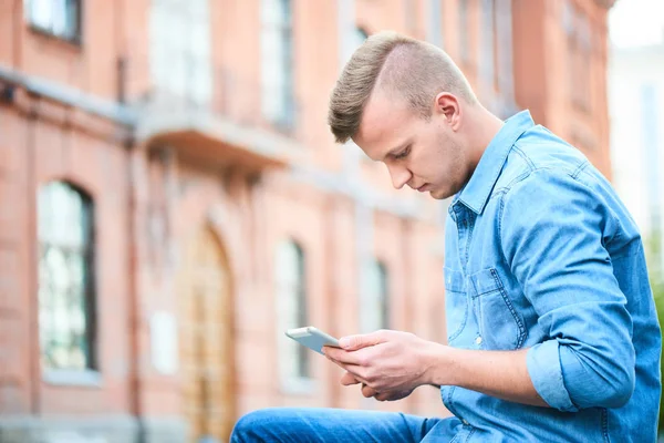 Estudiante Camisa Mezclilla Usando Tableta Mientras Está Sentado Cerca Universidad — Foto de Stock