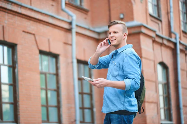 Estudiante Camisa Mezclilla Sosteniendo Tableta Hablando Por Teléfono Mientras Está — Foto de Stock