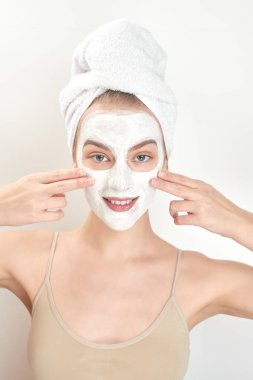 güzel bir kadınla kafa havluya ve yüzünde maske cilt bakım kavramı 