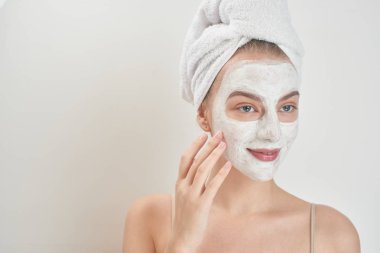 güzel bir kadınla kafa havluya ve yüzünde maske cilt bakım kavramı 
