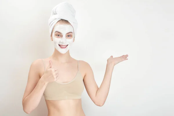 妇女用毛巾在头和面具在面孔显示拇指 皮肤关心概念 — 图库照片