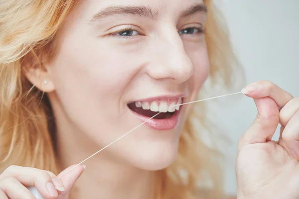 若い女性 デンタルフロスで歯を磨くクローズ アップ — ストック写真