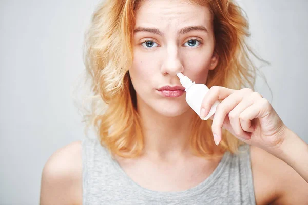 woman dripping nose drops, treatment of rhinitis concept