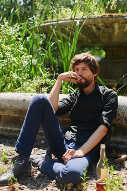 puro sigara ve Park eski Fountain'dan eğilerek güneşli gün rahatlatıcı bir adam