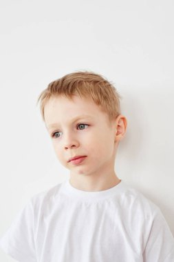 Beyaz t-shirt beyaz stüdyo arka plan üzerinde poz içinde küçük çocuk portresi