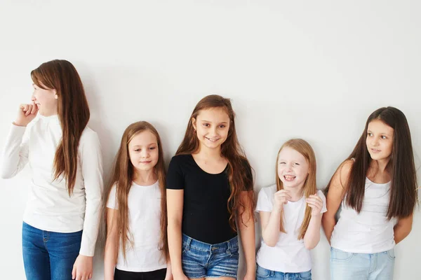 group of girls in casual clothes standing isolated on white background