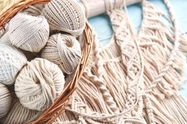 macrame threads in basket on wooden background, close-up clipart