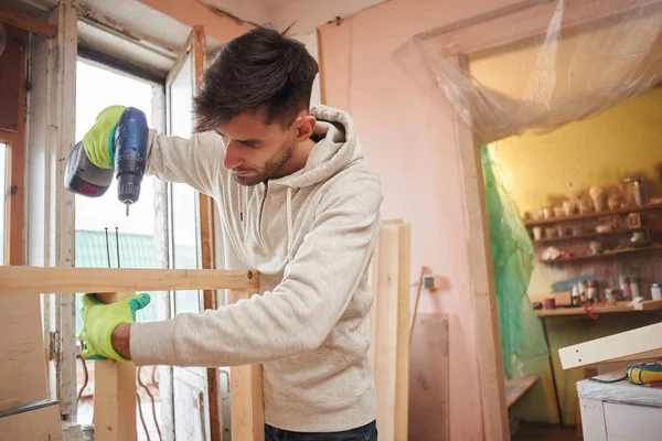 Junger Mann Baut Holzrahmen Mit Elektroschrauber Wohnung — Stockfoto