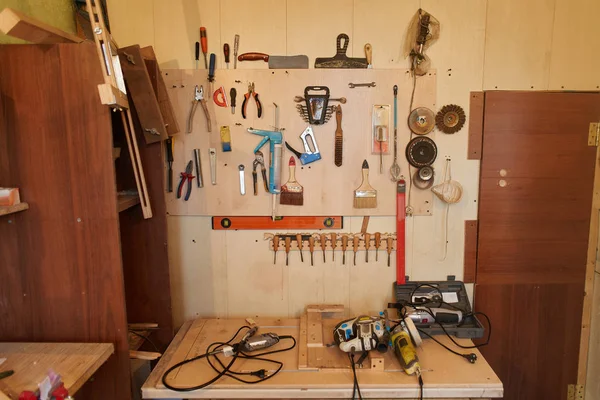 分类做自己的工具挂在木板墙上 — 图库照片