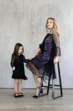 Anne ile kızı akşam dresse, gri studio arka planda, lookbook kavramı poz s  