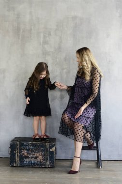 Anne ile kızı akşam dresse, gri studio arka planda, lookbook kavramı poz s  