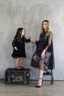 Anne ile kızı akşam dresse, gri studio arka planda, lookbook kavramı poz s  