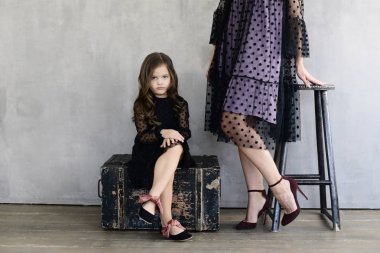 Anne Studio, lookbook kavramı yakınındaki ahşap kutu üzerinde oturan elbiseli küçük kızı 