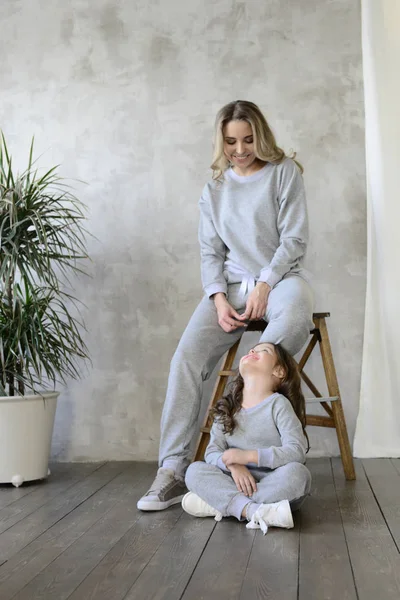 Mother Grey Soft Tracksuit Sneakers Sitting Wooden Chair Daughter Studio — Stock Photo, Image
