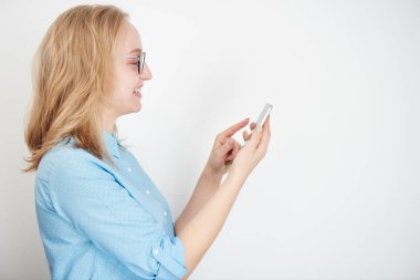 sarışın işkadını beyaz arka plan üzerinde izole smartphone kullanarak