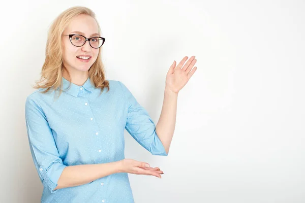 かわいい女性が身に着けている青いシャツと眼鏡脇を指す白い背景の分離 — ストック写真