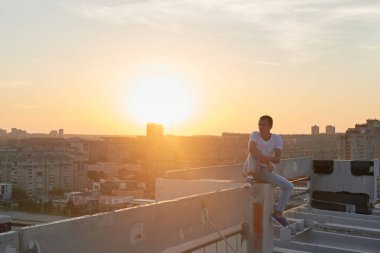 Bina, parkour kavramı çatı oturma rahat giyimli adam 