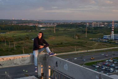 Bina, parkour kavramı çatı oturma rahat giyimli adam 