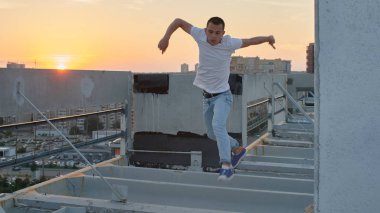 adam arka plan günbatımı, parkour kavramı, cityscape ile çatıya atlama 