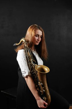 saksafon siyah arka planda tutan kadın 