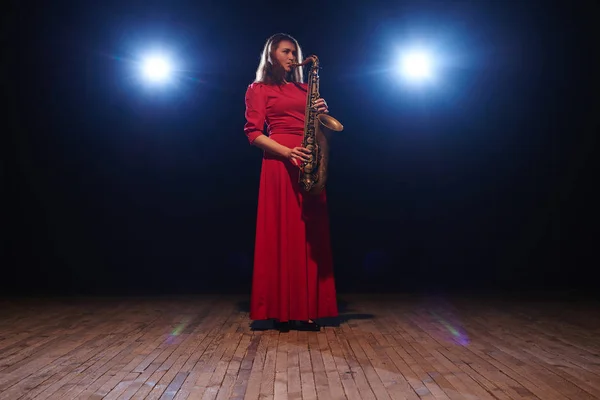 Hudebník Žena Červené Dlouhé Večerní Šaty Saxofon Jevišti Reflektory Pozadí — Stock fotografie