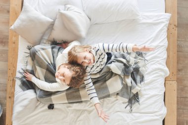 Anne ve kızı yatağa evde otururken eğleniyor 