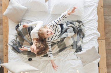 Anne ve kızı evde yatakta yastık atma 