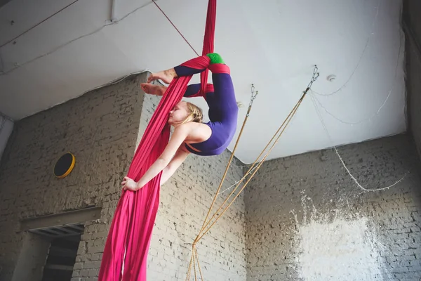 teen girl doing gymnastics on aerial silk