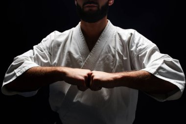 Karate adam yumruk bir arada siyah arka planda tutan kimono içinde