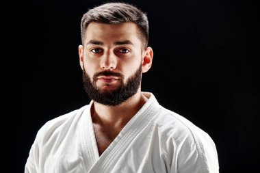 Kamera siyah arka plan karşı dikkatle bakarak kimono içinde ciddi sakallı adam portresi