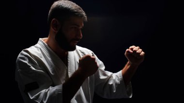 yan bakış beyaz ana karate giyen kimono koyu arka plan üzerinde poz duruş mücadelede
