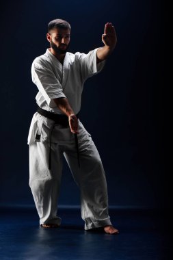 Siyah arka plan üzerinde duruş mücadelede kimono erkekte karate