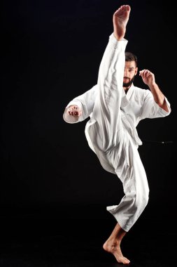 Karate adam ayak siyah arka plan üzerine isabet kimono içinde