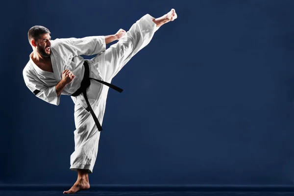 Karate Hombre Kimono Golpeando Pie Sobre Fondo Azul — Foto de Stock