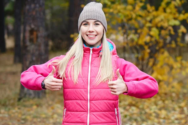 Blonde Woman Warm Sportswear Showing Thumbs While Standing Autumn Park — Stock Photo, Image