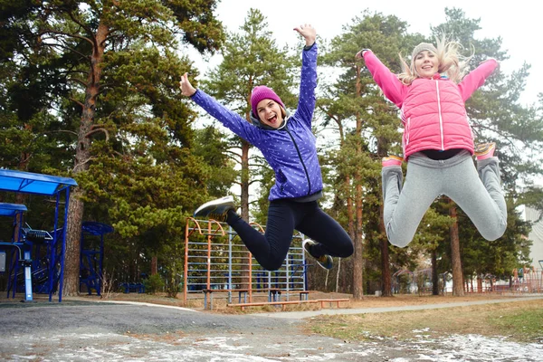 Смешные Женщины Теплой Одежде Прыгают Детской Площадке Парке — стоковое фото