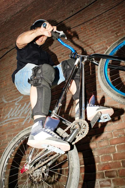 Athletic Bicyclist Jumping Rear Wheel Cycle Effort Blurred Red Brick — Stock Photo, Image