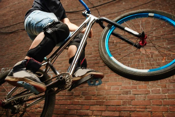 arka tekerlek kırmızı tuğla binanın duvarının yakınında bisiklet sürme bisikletçi