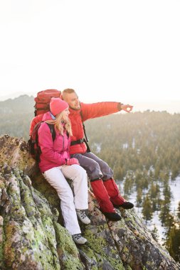  ileri ile kadın dağın tepesinde otururken işaret eden adam