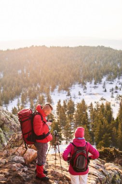 yürüyüşçüler Turistik arka çantalar tripod dağın zirvesinde fotoğraflarla yapıyor sırt ile