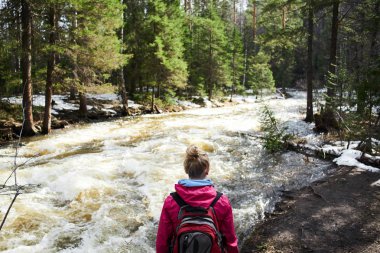 kıyıda duran ve orman, turizm kavramı içinde akan nehir bakarak sırt çantası kadınla 