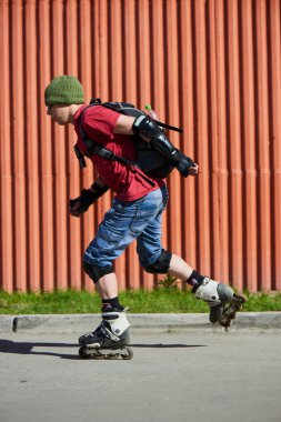 adam güneşli gün kırmızı duvar karşı hile yaparak silindirler üzerinde