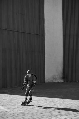 Bina arka plan üzerinde kırmızı patenci ile sırt silindir üzerinde sürme ekipman çantasında skates 